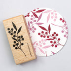Rubber stamp with wildberry design next to a circular product with similar pattern on a light gray background