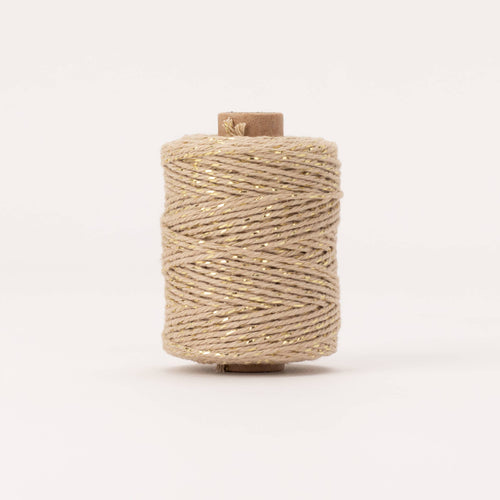 Spool of beige thread on a white background