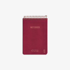 Red notebook with spiral binding on a white background