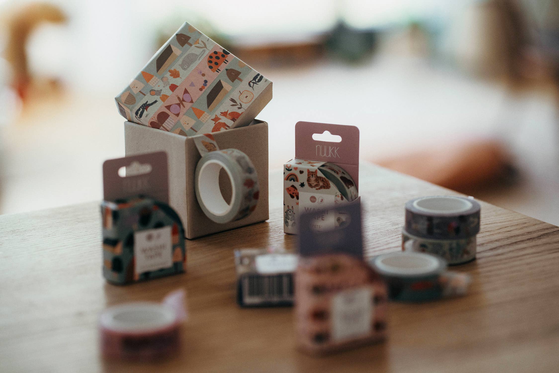 Various masking tapes and their packaging on a wooden surface. 