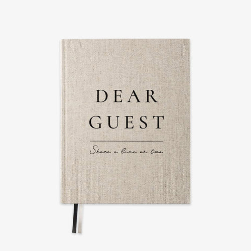 A linen-textured hardcover notebook with black printed text reading 'DEAR GUEST' and 'Share a line or two' on a clean white background.