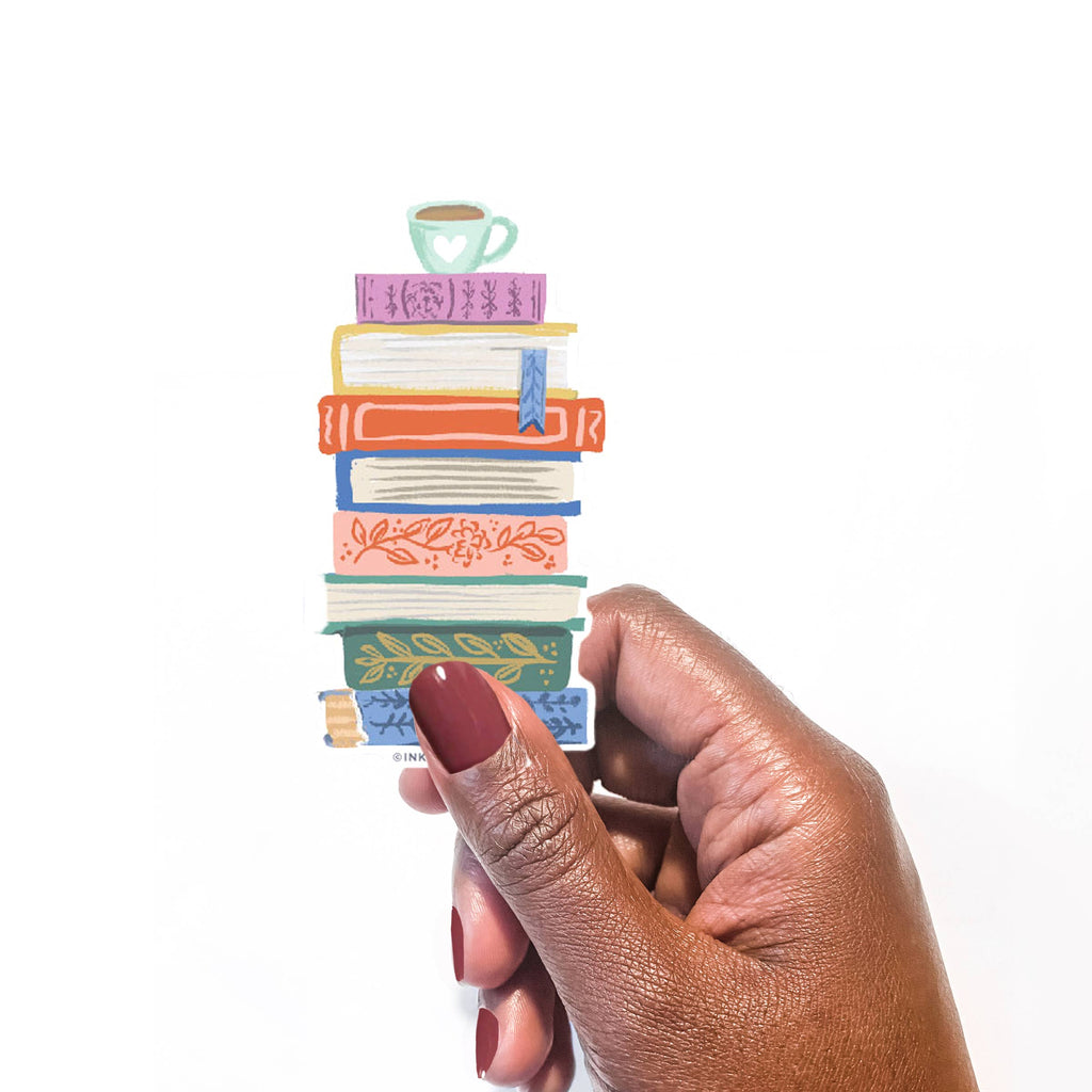 Colorful stack of books vinyl sticker held by a hand on a white background