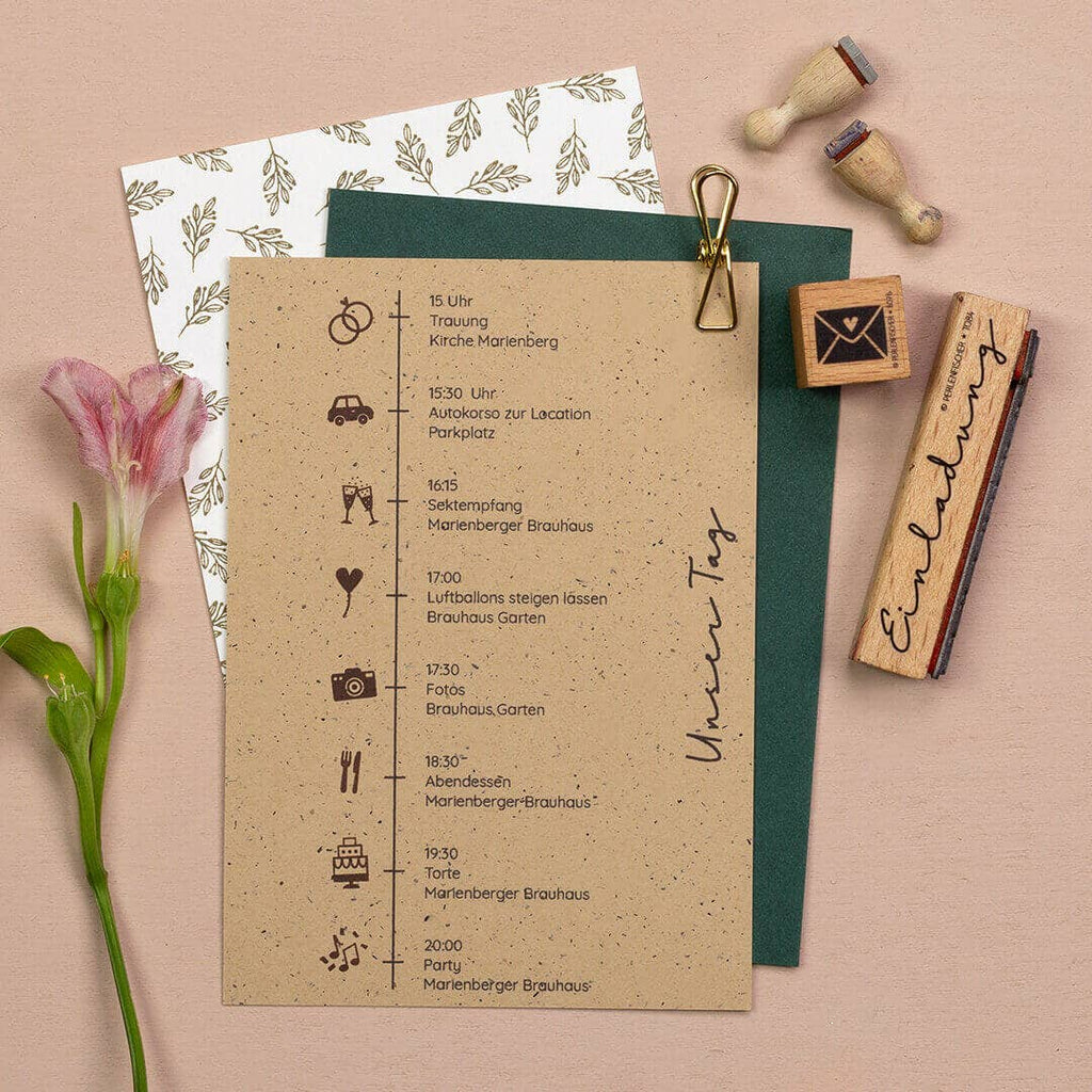 Wedding invitation with icons, stamps, and a flower on a beige background
