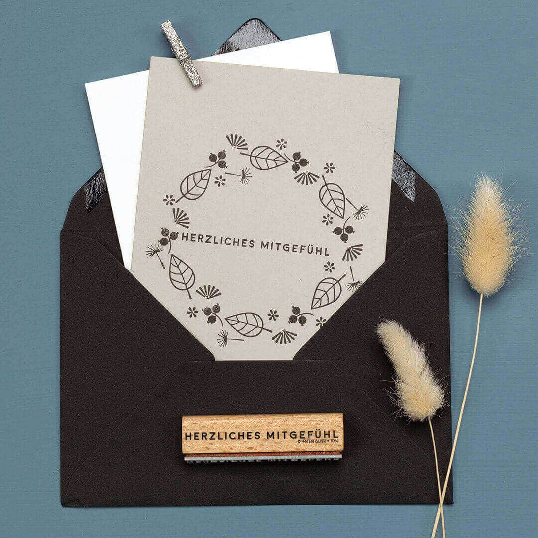 Greeting card with floral design and text in a black envelope on a blue background