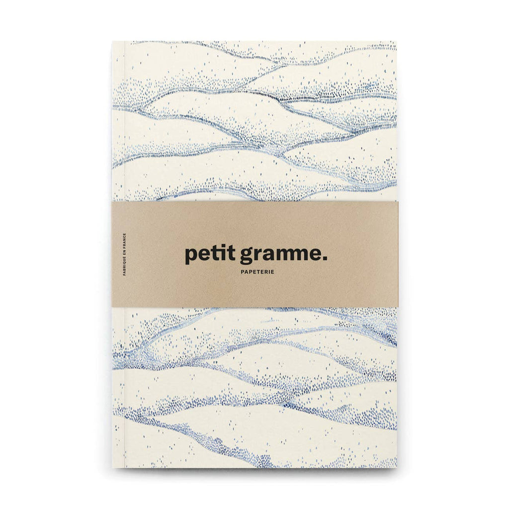 Notebook with wavy pattern and 'petit gramme' branding on a white background
