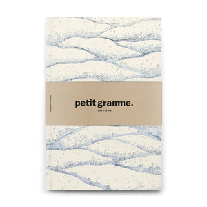 Notebook with wavy pattern and 'petit gramme' branding on a white background