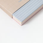 Close-up of a memo card with lined pages on a light background
