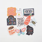 Collection of colorful vinyl stickers with various designs and messages on a white background