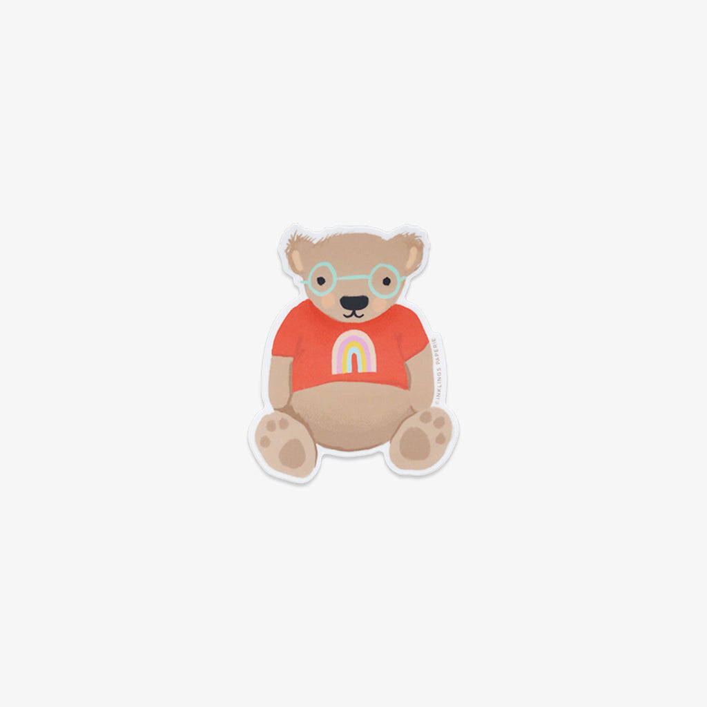Vinyl sticker of a bear wearing glasses and an orange shirt with a rainbow on a white background