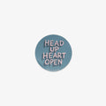Round vinyl sticker with 'Head Up Heart Open' text on a light blue background