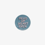 Round vinyl sticker with 'Head Up Heart Open' text on a light blue background
