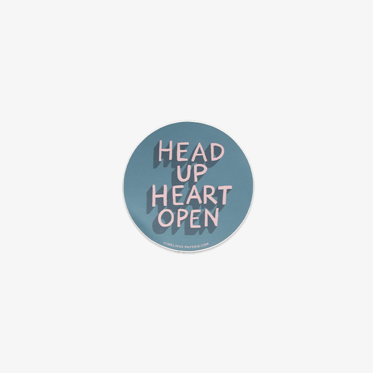 Round vinyl sticker with 'Head Up Heart Open' text on a light blue background