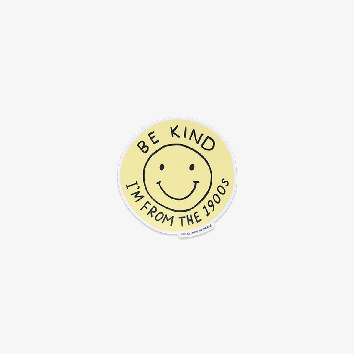 Round yellow sticker with smiley face and text 'Be kind, I'm from the 1900s' on a white background