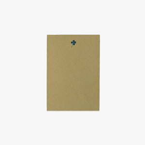 Green notepad with a dark green clover design on a white background