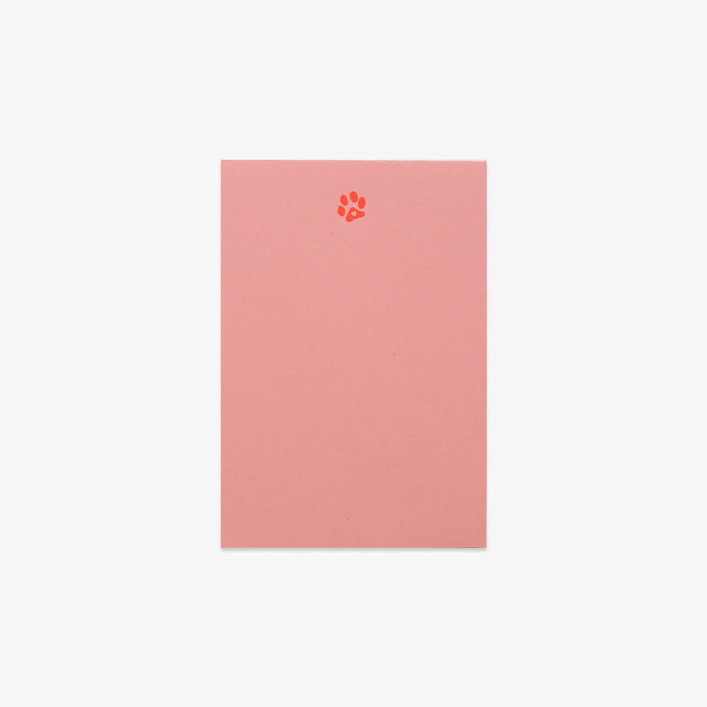 Pink notebook with a paw print design on a white background