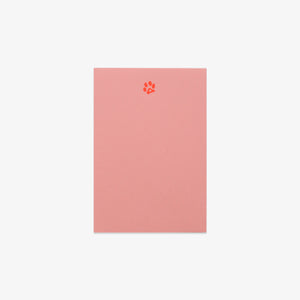 Pink notebook with a paw print design on a white background