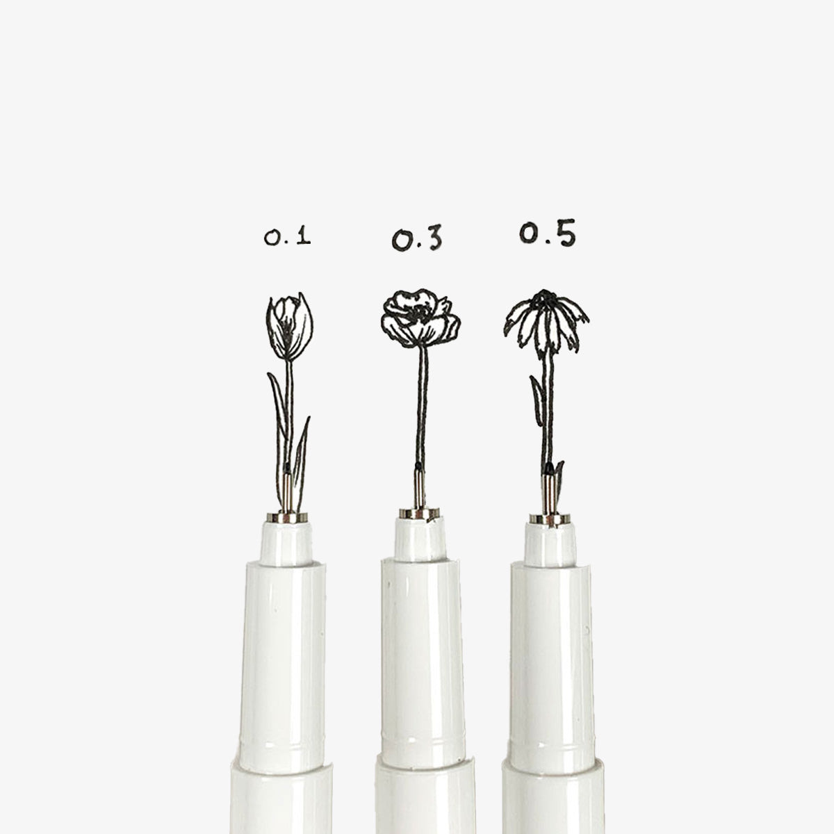 Three pen tips with black ink drawing flowers with different sizes.