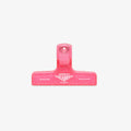 Pink binding clip on a white background
