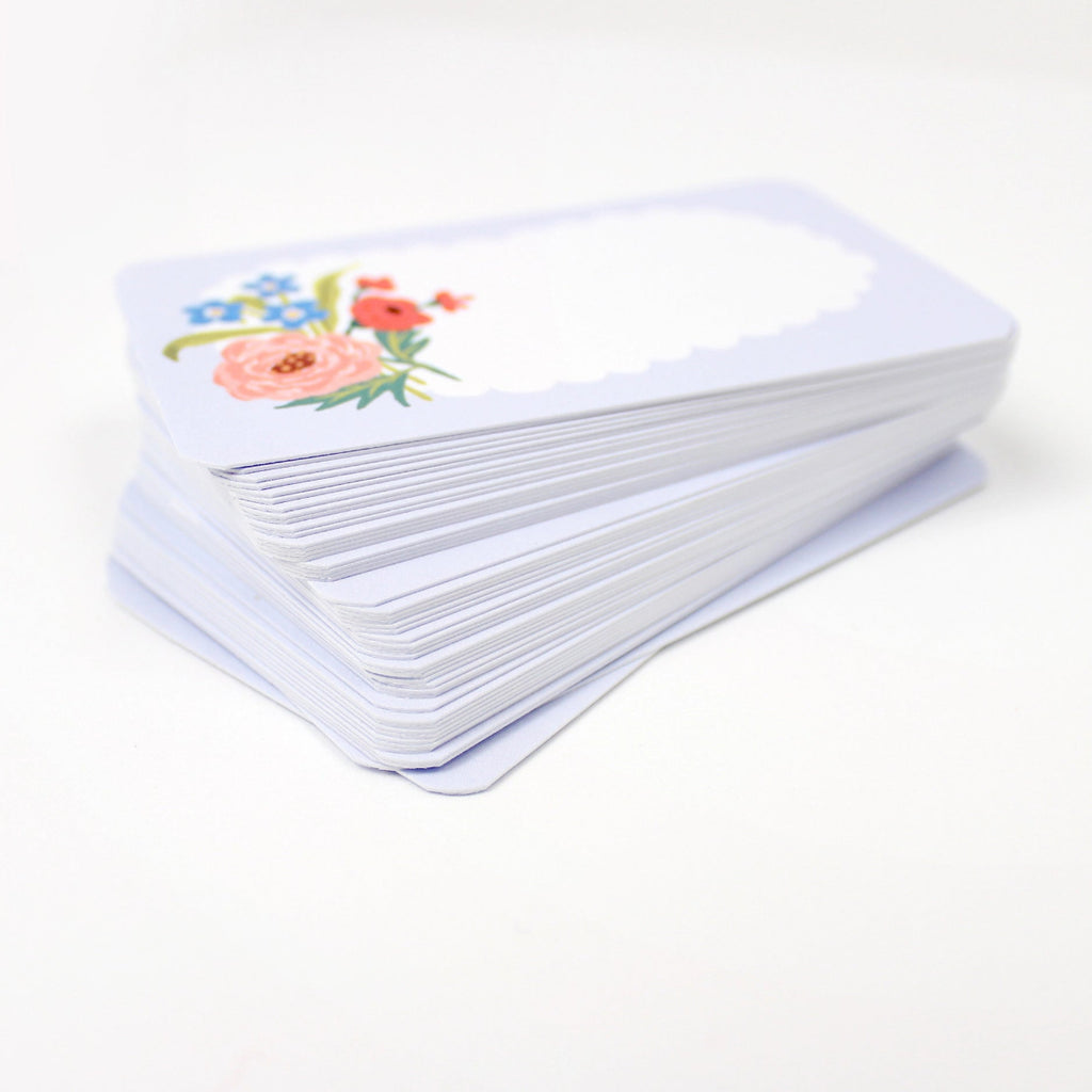Stack of white cards with floral designs on a white background
