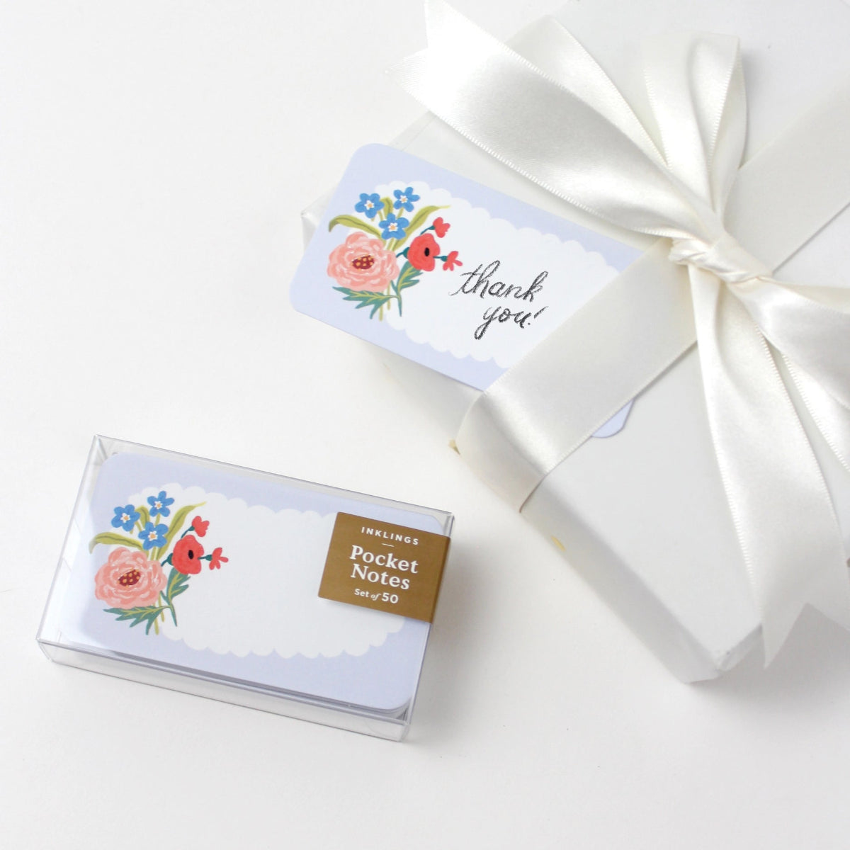 Box of pocket notes with floral design and 'thank you' card on a white background
