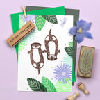 Card with otter illustrations and stamps on a purple background